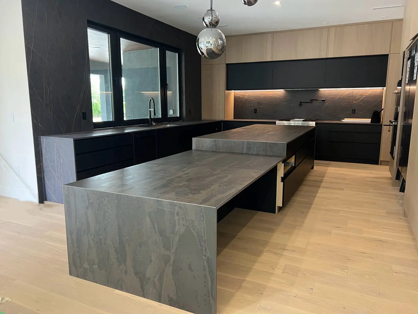 Modern dark kitchen with quartz countertop and pendant lighting